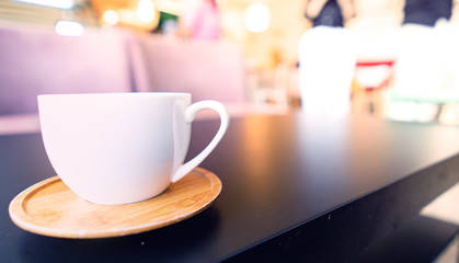 hot tea in white cup on black table in coffee shop