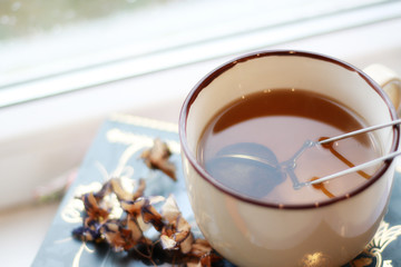 cup of tea ob the pile of books