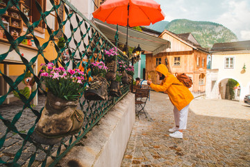 woman taking picture on her phone at hallstatt city streets