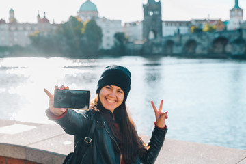 woman taking selfie with charles bridge on background