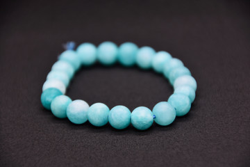 Homemade bracelet from Blue semi-precious stone beads on black background