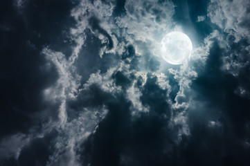 Fototapeta na wymiar Landscape of sky with dark clouds at nighttime. Beautiful full moon behind cloudy with moonlight.