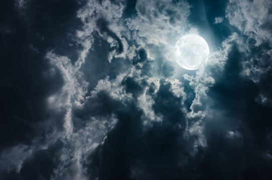 Landscape of sky with dark clouds at nighttime. Beautiful full moon behind cloudy with moonlight.
