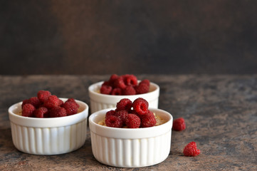 Cheesecake - The classic dessert cheese cream with raspberries. Dessert on the kitchen table. Souffle with cream and berries.