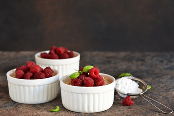 Cheesecake - The classic dessert cheese cream with raspberries. Dessert on the kitchen table. Souffle with cream and berries.