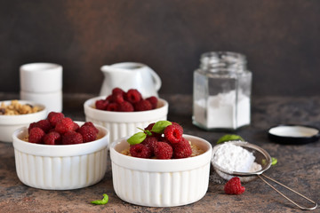 Cheesecake - The classic dessert cheese cream with raspberries. Dessert on the kitchen table. Souffle with cream and berries.
