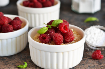 Cheesecake - The classic dessert cheese cream with raspberries. Dessert on the kitchen table. Souffle with cream and berries.