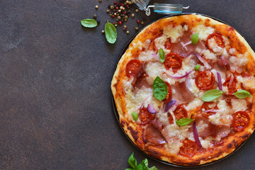Classic pizza with tomato sauce, salami and prosciutto on a concrete background. View from above .