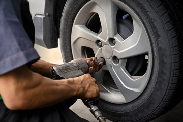 Man using car mechanic Block the wind wheel. To check your tires and brake for car.Auto mechanic Preparing For the work.