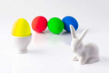 Easter bunny and multi-colored Easter eggs on a white background. Close up. Selective focus. Beauty Easter card.