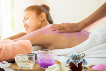 Obraz na płótnie Canvas Spa therapist scrub salt on young woman back and body at spa salon