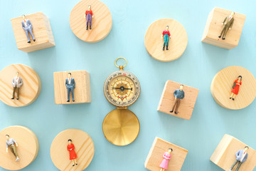 Business concept image of group of miniature people and compass. Metaphor of society structure and...