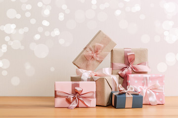 set of beautiful different gift boxes made by handmade with pink bows on a wooden table with a light background. flat lay