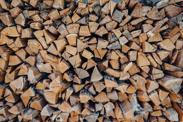 Preparation of firewood for the winter. firewood background, Stacks of firewood in the forest. Pile of firewood.