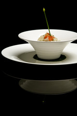 White turnip tagliatelle in a white bowl. Exquisite dish. Creative restaurant meal concept. Haute couture food on black with reflexion. Fine dining concept.