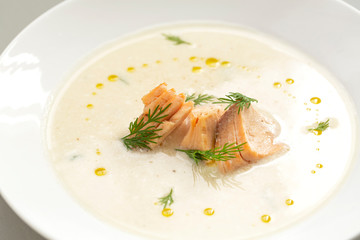 Finnish creamy soup with wild salmon. A bowl of creamy soup with salmon. Healthy food. Close up, selective focus. 