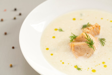 Finnish creamy soup with wild salmon. A bowl of creamy soup with salmon. Healthy food. Close up, selective focus. 