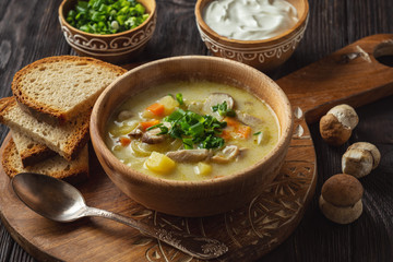 Homemade wild mushroom soup on wooden tray.
