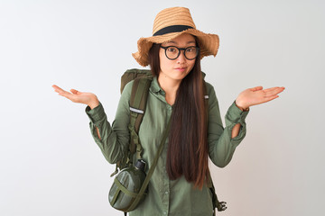 Chinese hiker woman wearing canteen hat glasses backpack over isolated white background clueless...