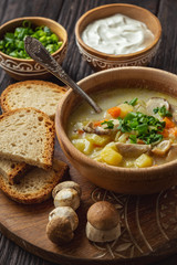 Homemade wild mushroom soup on wooden tray.