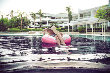 summer holiday by the pool . Woman on an inflatable donut
