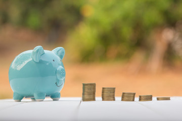 Piggy and coins placed on a pile of money saving on wooden table. Business financial concept