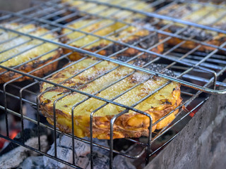 Slices of fresh pineapple sprinkled with sugar are fried on the grill 