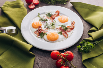 Toasted eggs with bacon on a white dish.