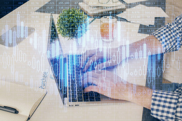 Multi exposure of graph with man typing on computer in office on background. Concept of hard work....