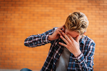 Unrecognizable young man getting devastating news on the phone.