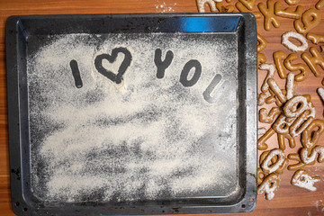 on a baking tray sprinkled with icing sugar or flour the words i Love you is written