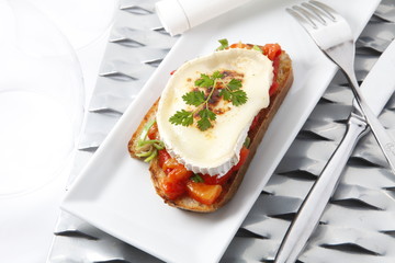 pincho aperitivo tapa, queso y tomate sobre bandeja.  con cubiertos. Tapa appetizer skewer, cheese and tomato on a tray. with cutlery.