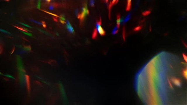 Sparks motion background. Prism effect. Multicolor flowing flecks on black.