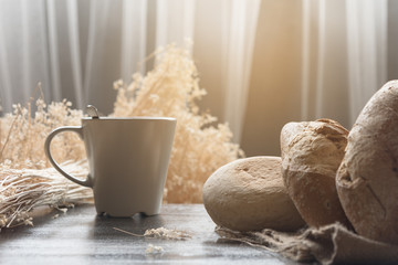 Many kind of bread put on handmade cloth on wooden table,prepare serve for breakfast or another meal.