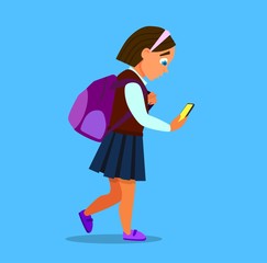 the little girl uses her smartphone, looks at the video, is happy, dressed in jeans, isolated on blue background, copy space