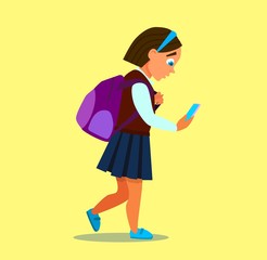 the little girl uses her smartphone, looks at the video, is happy, dressed in jeans, isolated on blue background, copy space