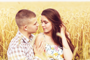 A girl in love and her boyfriend are hugging on a wheat field. Family camping