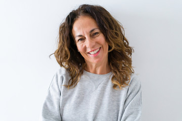 Beautiful middle age woman with curly hair smiling cheerful and happy, laughing with a big smile on face showing teeth over white isolated background