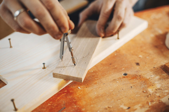 A man carves a tree. The carpenter works in a studio. An engineer provides a tree shape