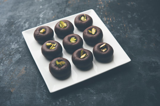 Chocolate Milk peda or pera or pedha made using sweet condensed Milk and cocoa powder, garnished with Pistachio. selective focus