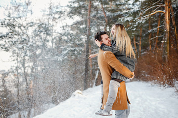 happy couple playing with snow in the park