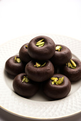 Chocolate Milk peda or pera or pedha made using sweet condensed Milk and cocoa powder, garnished with Pistachio. selective focus