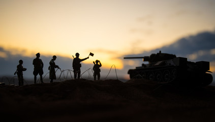 Fototapeta na wymiar War Concept. Military silhouettes fighting scene on war fog sky background, World War German Tanks Silhouettes Below Cloudy Skyline At night. Attack scene.