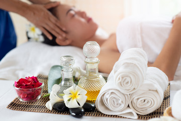 Fototapeta na wymiar Happy Asian woman receiving head massage, enjoying and relaxing in spa salon