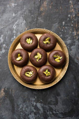 Chocolate Milk peda or pera or pedha made using sweet condensed Milk and cocoa powder, garnished with Pistachio. selective focus