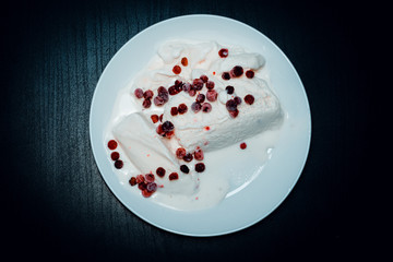 Ice cream on a white plate on dark wood
