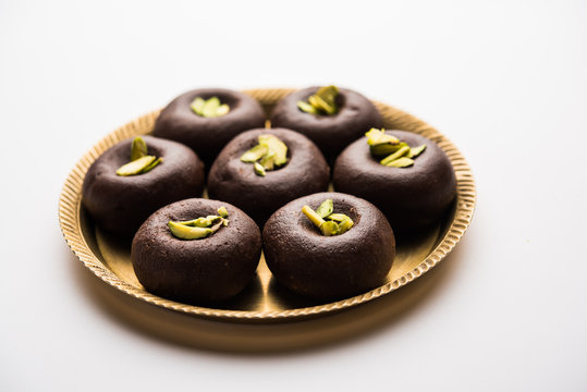 Chocolate Milk peda or pera or pedha made using sweet condensed Milk and cocoa powder, garnished with Pistachio. selective focus