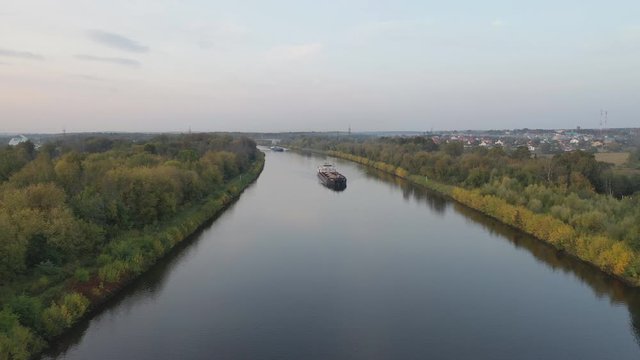 Air view of the movement of the barge on the shipping channel in the area of locks and construction of the bridge