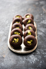 Chocolate Milk peda or pera or pedha made using sweet condensed Milk and cocoa powder, garnished with Pistachio. selective focus