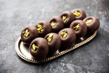 Chocolate Milk peda or pera or pedha made using sweet condensed Milk and cocoa powder, garnished with Pistachio. selective focus